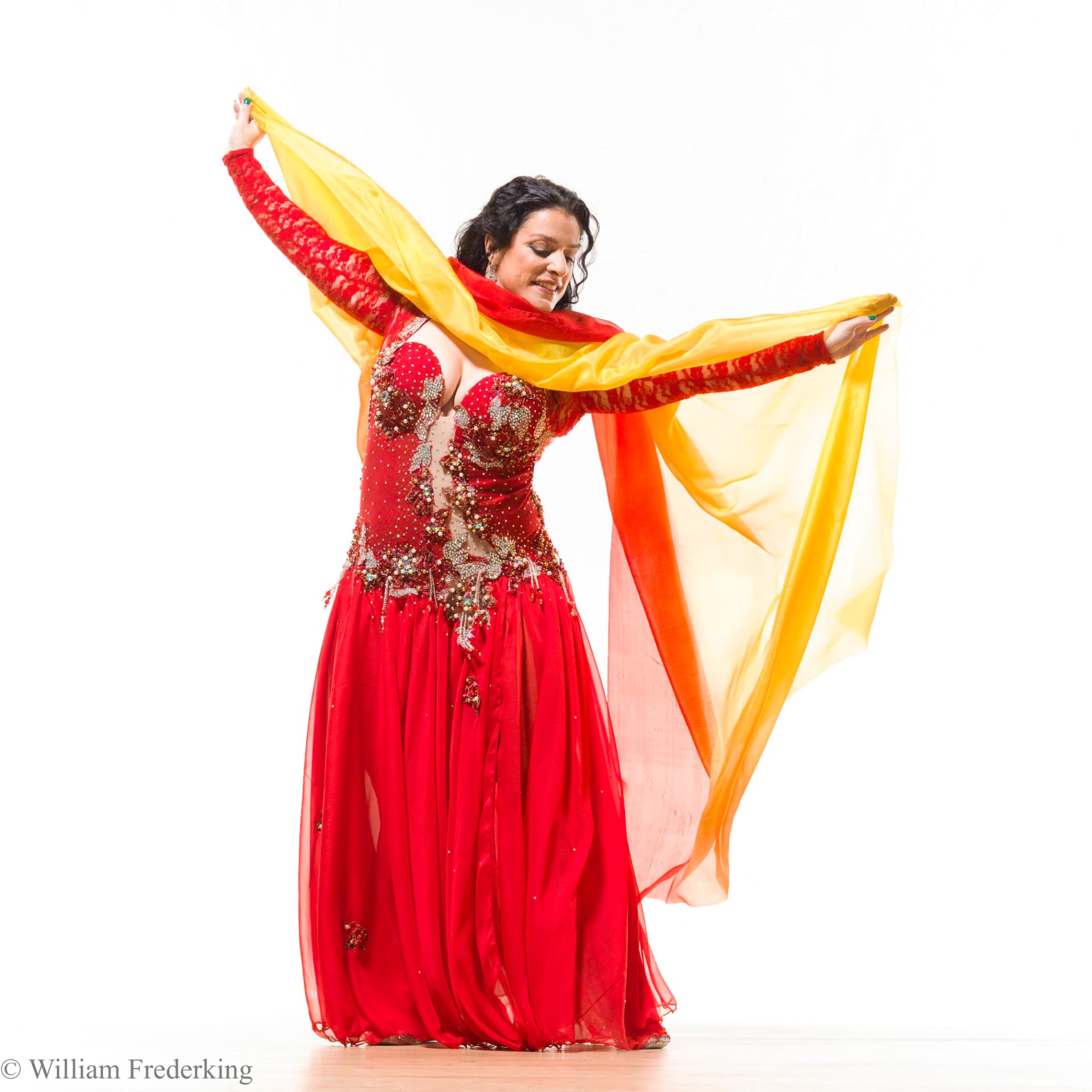 Phaedra Darwish dancing with a sunrise-colored veil